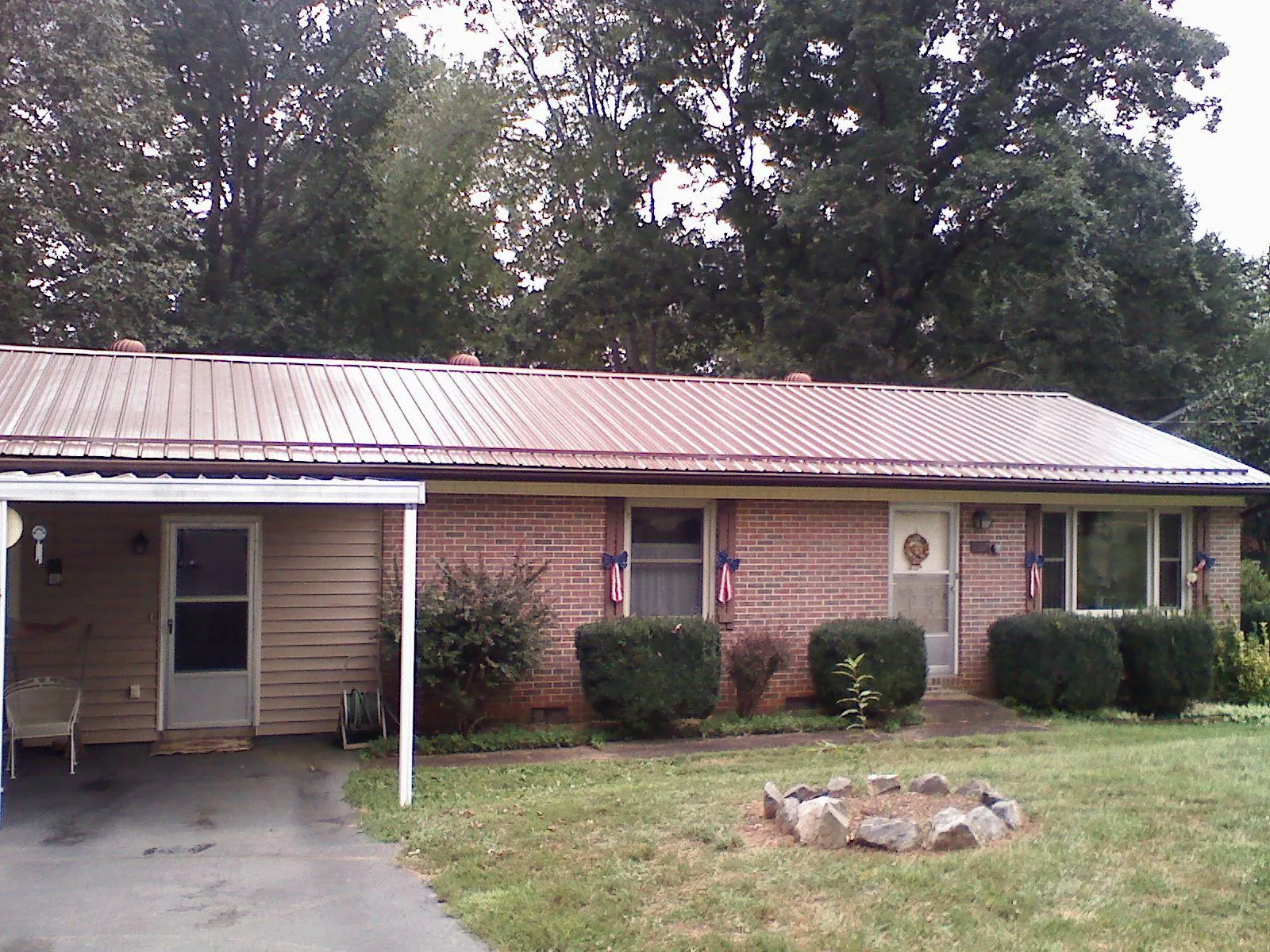 Bronze metal roof and carport on a brick ranch home — Roof Repair work by our crew in Cement City