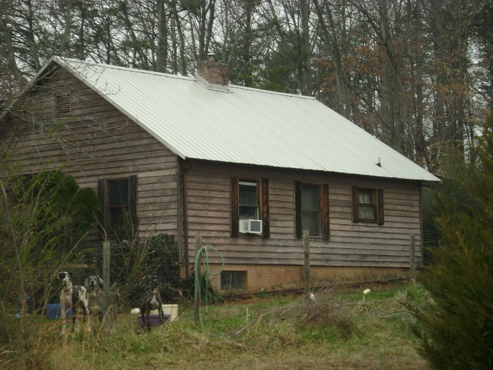 White metal roof on an old wood sided farmhouse, from a Metal Roof Installation job in Cement City